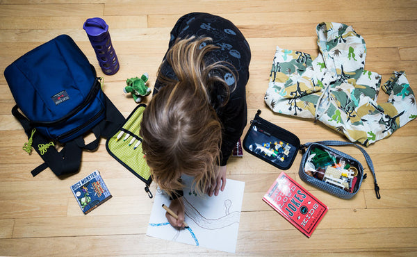 A child coloring a picture surrounded by accessories and The Sprout.